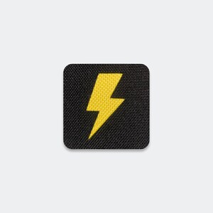 May include: A square-shaped patch featuring a black fabric base with a textured weave. Centered on the patch is a bright yellow lightning bolt icon. The edges of the patch are rounded, and the design is flat with a clean, embroidered appearance.