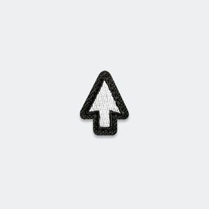 May include: A small embroidered patch in the shape of a computer mouse cursor arrow. The design features a white triangular arrow head with a thick black border, rendered in detailed thread work with a textured finish on the surface of the patch.