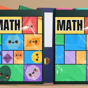May include: Two green binders with the word "MATH" on the front, each with a colorful geometric design featuring smiling shapes. The binders are in front of other colorful binders, including red, blue, and yellow.
