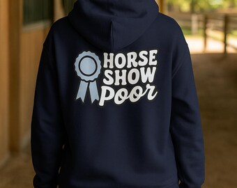 May include: Navy blue hoodie with the text "HORSE SHOW POOR" in white, accompanied by a light blue ribbon graphic. The hoodie is a casual garment, suitable for equestrian enthusiasts.