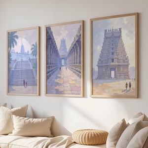 Puede incluir: Tres impresiones artísticas enmarcadas que representan templos antiguos. La obra de arte presenta representaciones arquitectónicas detalladas en colores pastel suaves, con figuras y palmeras. Los marcos son de color madera clara y las impresiones se exhiben sobre un sofá color crema.