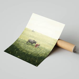 May include: An art print depicting a rural scene with a dark gray water buffalo grazing in a green field. A person in red clothing is also in the field. The print is rolled up and held by a brown cardboard tube.