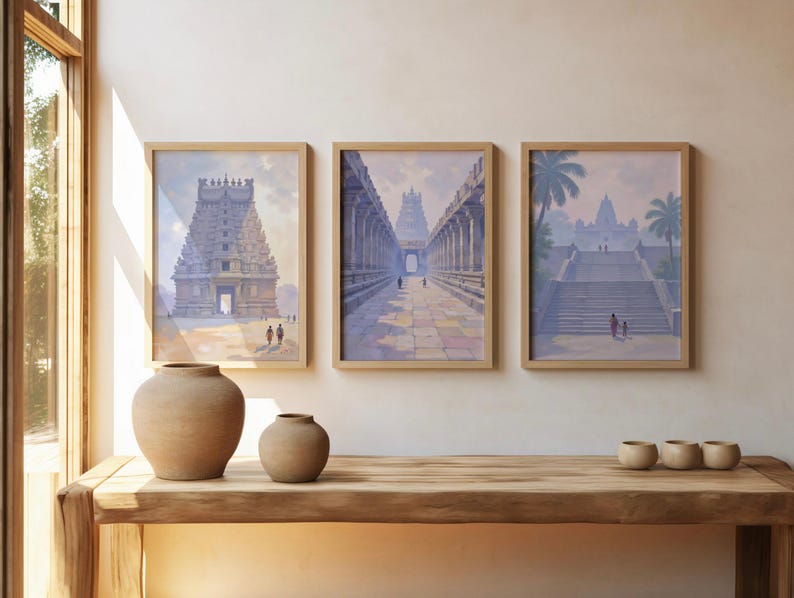 May include: Three framed prints depicting ancient temples in shades of blue, gray, and beige. The prints are displayed above a wooden table with two ceramic vases and three small bowls. The room has a window with natural light.