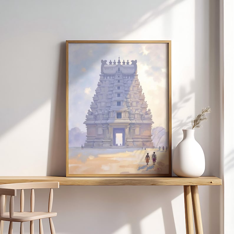 May include: Framed print of a temple with a detailed, multi-tiered structure, painted in soft blues and tans. The artwork features a golden frame and is displayed on a wooden table. A white vase with dried plants sits to the right.