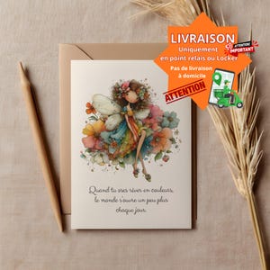 Puede incluir: Una tarjeta de felicitación con una ilustración de acuarela de un hada rodeada de flores coloridas. El hada lleva un vestido arcoíris y tiene flores en el pelo. La tarjeta está sobre un sobre beige con un lápiz.