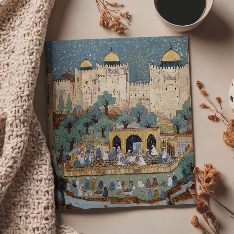 May include: A square art print depicting a Middle Eastern city with a fortress, trees, and figures in traditional dress. The artwork uses blues, golds, and creams, with a starry sky. A cup of coffee and a beige knitted blanket are in the background.