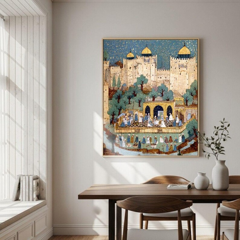 May include: A framed artwork showing a Middle Eastern palace scene with a blue sky. The artwork features a gathering of people, trees, and architectural details in gold, blue, and green. The artwork is displayed on a white wall above a wooden table in a dining room.