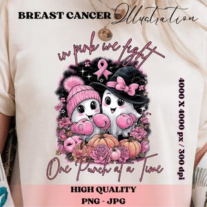 May include: A light-colored t-shirt featuring a graphic illustration with the text "BREAST CANCER Illustration". The design includes two cartoon ghosts wearing pink boxing gloves, hats, and surrounded by pink flowers and pumpkins. The text "in pink we fight" and "One Punch at a Time" are also included.