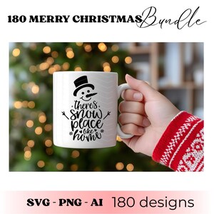 May include: White ceramic mug with a snowman design and the text "there's snow place like home." The mug is held in a hand with a red and white sweater sleeve. The image also includes the text "180 MERRY CHRISTMAS Bundle" and "SVG - PNG - AI 180 designs."