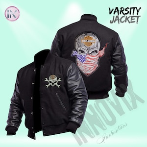 May include: Black varsity jacket with leather sleeves. The jacket features a skull and crossbones patch on the front and a larger skull design on the back, with a bandana in the colours of the American flag. The text "VARISTY JACKET" is displayed.