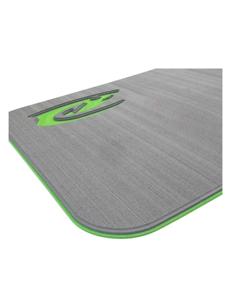 May include: A gray rectangular mat with a textured surface and a green border. The mat features a green logo in the upper left corner. The mat is designed for exercise and fitness activities.