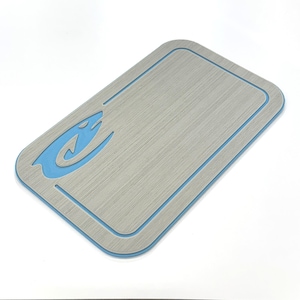 Puede incluir: Tabla de cortar rectangular gris con borde azul y logotipo de pez azul en la esquina superior izquierda. La tabla tiene una superficie texturizada y esquinas redondeadas. Mide aproximadamente 30 cm de largo y 20 cm de ancho.