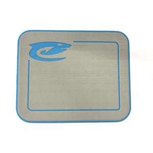 K&ouml;nnte beinhalten: Quadratische Platte aus geb&uuml;rstetem Metall mit hellblauem Rand und passendem Logo in der oberen linken Ecke. Das Logo ist eine stilisierte Wasserlebewesen. Die Platte hat abgerundete Ecken.