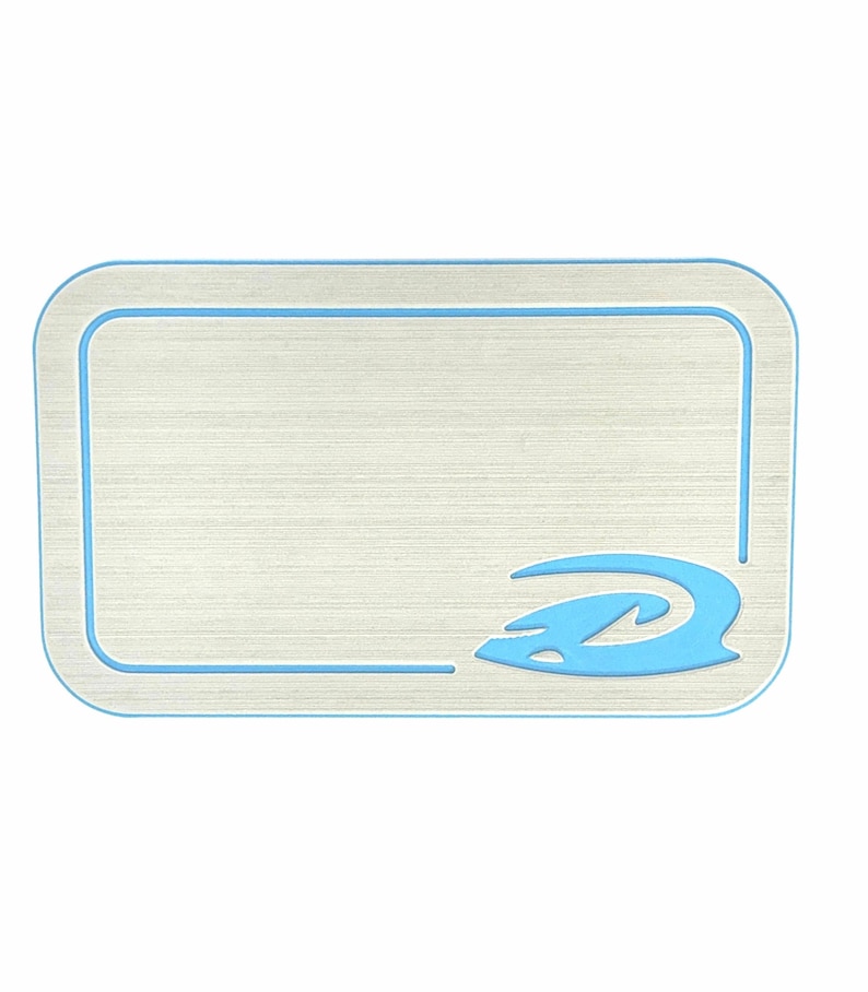 Puede incluir: Una alfombrilla rectangular de color claro con aspecto de metal cepillado. Presenta un borde azul claro y un emblema azul estilizado en la esquina inferior derecha. La alfombrilla tiene esquinas redondeadas y un dise&ntilde;o limpio y moderno.