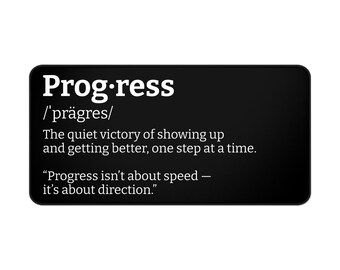 Könnte beinhalten: Ein schwarzes rechteckiges Schild mit abgerundeten Ecken zeigt das Wort "Progress" in Weiß, zusammen mit seiner Aussprache. Darunter definiert der Text Fortschritt als den stillen Sieg, aufzutauchen und sich zu verbessern, Schritt für Schritt. Ein Zitat über die Richtung ist ebenfalls enthalten.