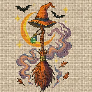 Pode incluir: Um desenho de ponto cruz com um chapéu de bruxa em cima de uma vassoura, com uma lua crescente, morcegos, estrelas e folhas de outono. O chapéu é laranja, a vassoura é castanha e laranja, e o fundo é bege.