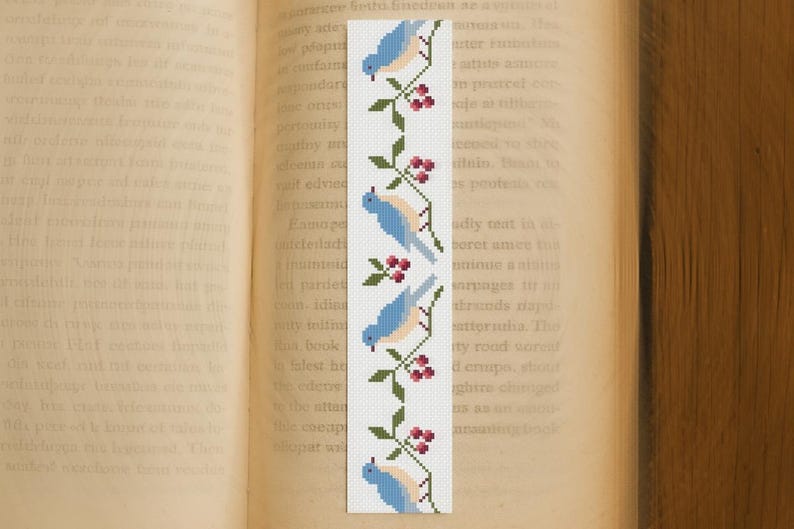 Blue birds and berries cross stitch bookmark pattern displayed on an open book, instant PDF download design