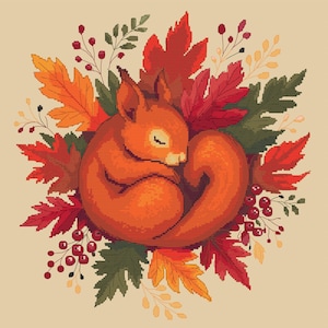 May include: A cross-stitch design of a sleeping squirrel curled up in a ball, surrounded by autumn leaves and berries. The squirrel is orange, and the leaves are shades of red, orange, and green. The background is a light beige.