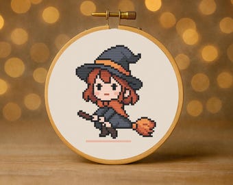 May include: A cross-stitch embroidery in a wooden hoop depicts a pixelated witch with red hair, a black hat with an orange band, and a black cloak. She is riding a broom with an orange handle. The background is a soft, neutral colour.