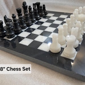 Pu&ograve; includere: Un set di scacchi da 20,32 cm x 20,32 cm con una scacchiera in pietra lucida bianca e nera e un set abbinato di pezzi degli scacchi in pietra intagliata bianca e nera disposti nelle posizioni iniziali sulla superficie a scacchi.