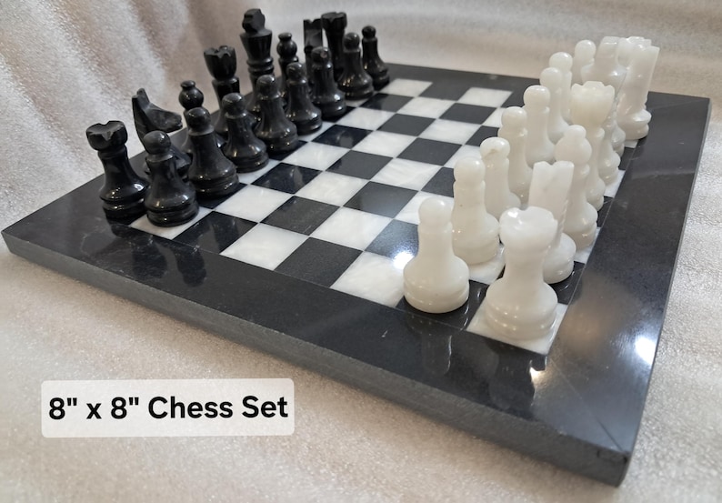 Pu&ograve; includere: Un set di scacchi da 20,32 cm x 20,32 cm con una scacchiera in pietra lucida bianca e nera e un set abbinato di pezzi degli scacchi in pietra intagliata bianca e nera disposti nelle posizioni iniziali sulla superficie a scacchi.