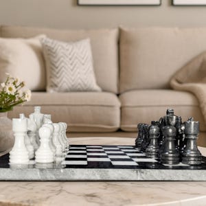 Pu&ograve; includere: Un set di scacchi in marmo con una scacchiera lucida a quadrati bianchi e neri alternati. Il set include una collezione completa di pezzi degli scacchi in marmo bianco e nero intagliati, tra cui pedoni, torri, cavalli, alfieri, regine e re.