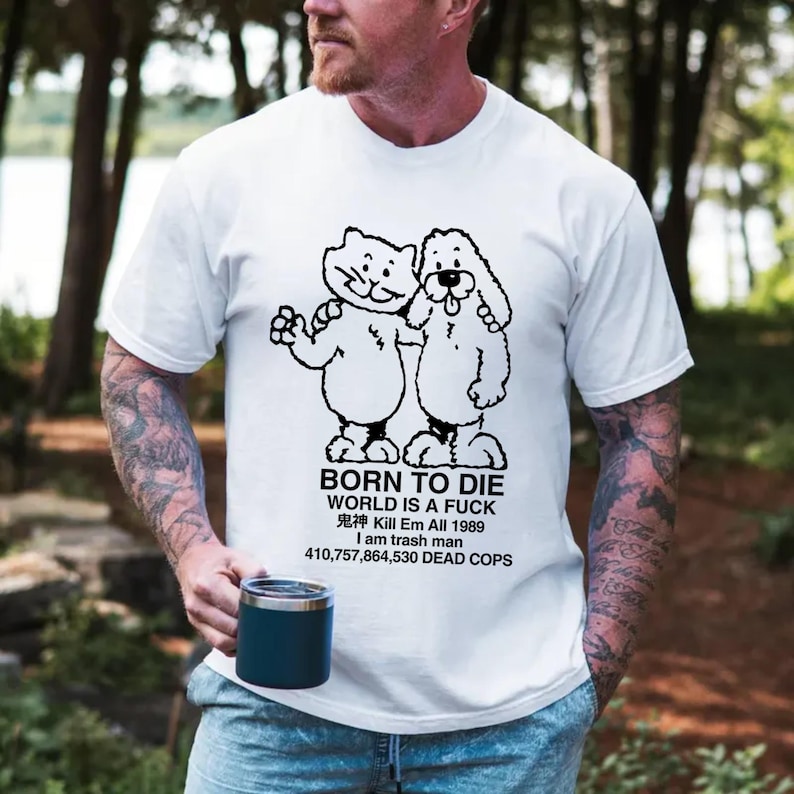 Pode incluir: Camiseta branca com um desenho preto de um gato e um cachorro abra&ccedil;ados. Abaixo da imagem, a frase: "BORN TO DIE WORLD IS A FUCK 鬼神 Kill Em All 1989 I am trash man 410,757,864,530 DEAD COPS".