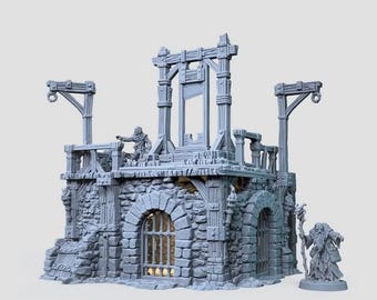 May include: A gray miniature stone dungeon structure featuring a central guillotine on a raised platform, arched doorways with iron bars, and wooden support beams. A small figure stands on the platform, and a robed figure with a staff stands nearby.