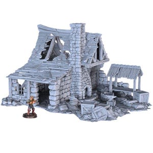 May include: A gray miniature model of a dilapidated stone building with a chimney, a damaged roof, and a small figure of a person. The model includes a forge, anvil, and other accessories, suggesting a blacksmith's shop. The overall theme is fantasy or tabletop gaming.