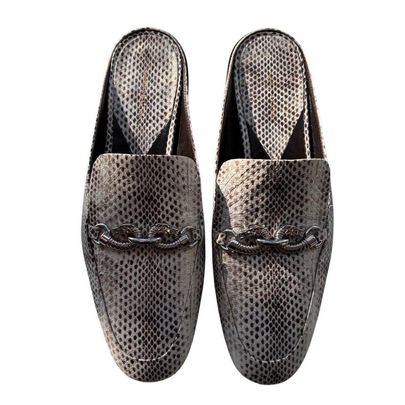 May include: A pair of slip-on loafers with a snakeskin pattern in shades of gray and white. Each shoe features a silver chain detail across the top. The shoes have a pointed toe and a low heel.