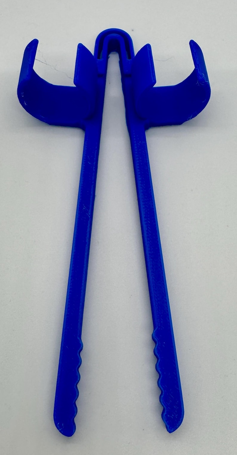 May include: A bright blue, 3D-printed tool with a unique shape. It features two long, parallel handles connected at the top by a curved bridge. The handles have a textured, scalloped edge near the bottom, and curved ends.