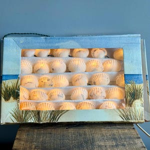 May include: A set of three ceramic mugs with a speckled, matte finish. The mugs are in shades of cream, light gray, and dark gray. Each mug has a simple, minimalist design and a rounded handle.