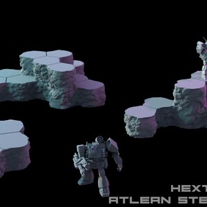 May include: A set of light blue, textured, hexagonal terrain pieces with rocky sides, featuring two distinct elevated formations and two small robotic figures. The text HEXTECH ATLEAN STEPPES VOL 7 is visible in the bottom right corner.