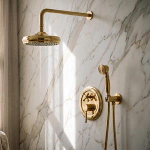 May include: A brushed gold shower system featuring a round overhead shower head on a horizontal arm, a circular wall-mounted control valve with a cross handle and lever, and a handheld shower wand connected by a flexible metal hose.