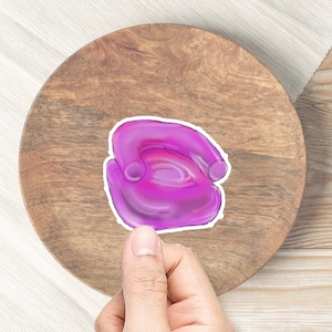 May include: A purple inflatable chair with a white outline. The chair is sitting on a wooden surface.