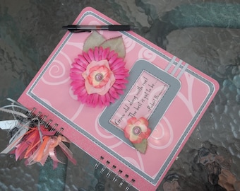 May include: Pink spiral bound journal with a pink flower and a quote by Robert Browning that reads "Grow old along with me! The best is yet to be..."
