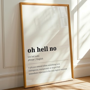 Könnte beinhalten: Ein gerahmter Druck mit dem Satz "oh hell no" in schwarzem Text. Die Definition des Satzes ist ebenfalls enthalten. Der Rahmen ist hellbraun und der Druck lehnt an einer weißen Wand auf einem Holzboden.