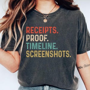 Könnte beinhalten: Dunkelgraues T-Shirt mit den Worten "RECEIPTS. PROOF. TIMELINE. SCREENSHOTS." in einem Retro-Schriftstil. Der Text ist in Rot, Türkis und Gelb gehalten. Das Shirt hat einen lässigen Stil.