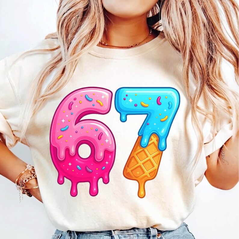 May include: Cream-colored sweatshirt featuring a colorful graphic of the number 67. The number 6 is designed as a pink donut with sprinkles, while the 7 is blue and dripping over a waffle cone. A fun, playful design.
