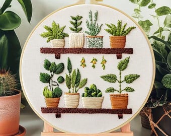 May include: An embroidered artwork depicting a collection of potted plants on two wooden shelves. The plants are in shades of green, with brown pots and shelves. The piece is displayed on a wooden easel, showcasing a botanical theme, with measurements in cm.