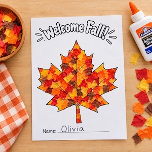 May include: A white paper craft sheet featuring the text Welcome Fall! at the top and a large maple leaf outline filled with small, torn pieces of red, orange, yellow, and brown tissue paper. The bottom includes a line for a name, written as Olivia.