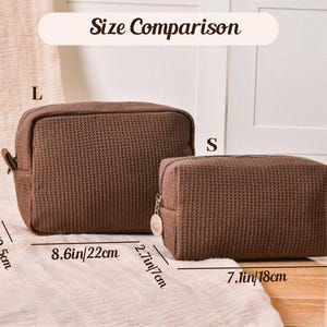 Pu&ograve; includere: Confronto delle dimensioni di due trousse marroni con texture a nido d'ape, etichettate 'L' e 'S'. La borsa pi&ugrave; grande &egrave; larga 22 cm e alta 16 cm. La borsa pi&ugrave; piccola &egrave; larga 18 cm e alta 11 cm.
