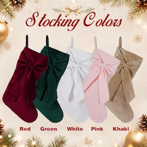 May include: Five velvet Christmas stockings with large bows, arranged in a row. The colours from left to right are deep red, dark green, white, light pink, and khaki. The text "Stocking Colors" appears at the top, with colour labels below.