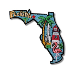 May include: Embroidered patch in the shape of Florida, featuring a rocket, palm tree, lighthouse, and flamingo. The word "FLORIDA" is embroidered in yellow and orange. The patch has a blue background and black border.