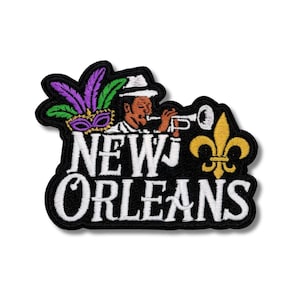 以下が含まれることがあります： 白い「NEW ORLEANS」の文字が黒い縁取りで刺繍されたパッチ。トランペットを演奏するミュージシャン、フルール・ド・リス、マスクや羽などのマルディグラの要素が含まれています。