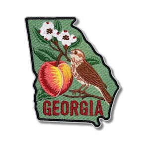 以下が含まれることがあります： ジョージア州の形をした刺繍パッチ。桃、鳥、花の咲いた枝が描かれています。「GEORGIA」の文字は赤で刺繍されています。パッチは緑色の背景と黒い縁取りです。