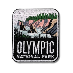 Puede incluir: Parche bordado que representa un paisaje costero del Parque Nacional Olímpico. El diseño incluye formaciones rocosas, árboles de hoja perenne y el texto "OLYMPIC NATIONAL PARK" en blanco sobre un fondo negro. El parche tiene un borde blanco.
