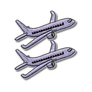 Puede incluir: Dos parches bordados de un avión lavanda con ventanas negras y borde blanco. Los parches son idénticos, mostrando la vista superior de la aeronave con alas y cola. Los parches están sobre un fondo blanco.