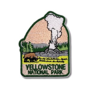 Może przedstawiać: Haftowana naszywka przedstawiająca krajobraz Parku Narodowego Yellowstone. Projekt zawiera gejzer w erupcji, bizona oraz napis "YELLOWSTONE NATIONAL PARK" w kolorze zielonym i żółtym. Naszywka ma zieloną obwódkę.