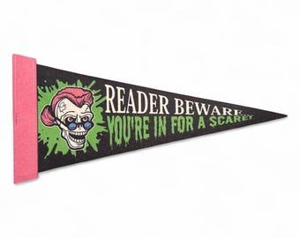 May include: Black pennant with pink trim featuring a skull with pink hair and blue glasses, surrounded by green splatters. Text reads "READER BEWARE YOU'RE IN FOR A SCAREY".